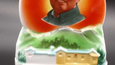 A ceramic bust of Mao with his childhood home below. There is Chinese calligraphy on the backside. It is a decoration for the home during the Cultural Revolution.