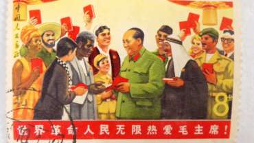 A postage stamp from the Chinese Cultural Revolution. Mao is autographing books for people from all across the world.